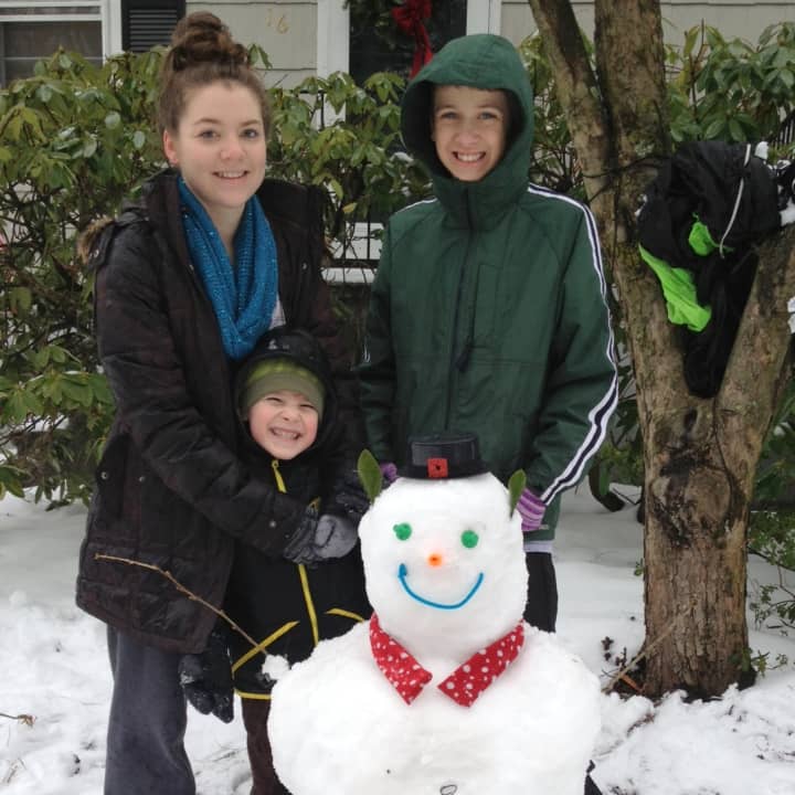 Taylor Copeland-York, left,  17, Luke Camarlinghi, 13, and Ethan Goormastic, 6, of New Canaan made a snowman Wednesday on their snowy day off from school. 