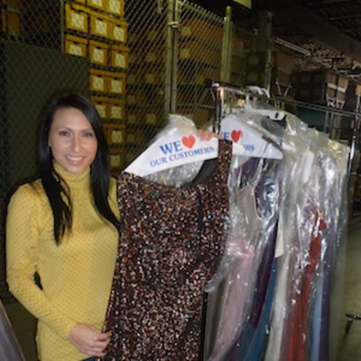 Noel D&#x27;Allacco, founder of Operation PROM, holds up a dress at the organization&#x27;s storage facility in Elmsford. Operation PROM is raising money for a Queens high school prom.