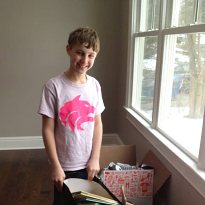 Westport student Ethan Brodows, 13, shows off some of the children&#x27;s books he&#x27;s collected so far. 