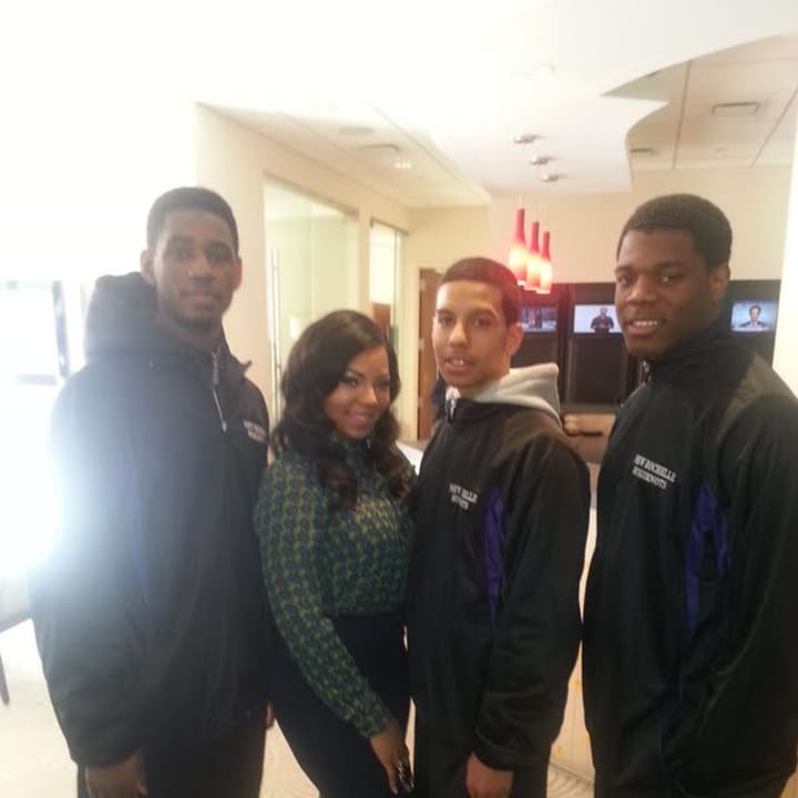 The New Rochelle boys basketball players and coach Rasaun Young with singer/actress Ashanti.