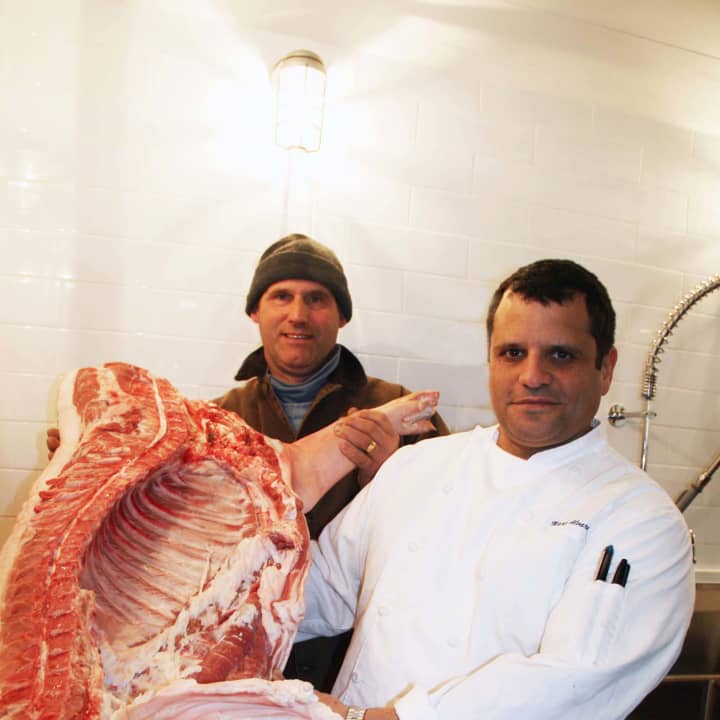 Pig farmer Craig Meili (left) and Purdy&#x27;s Farmer &amp; the Fish chef Marc Alvarez display the restaurant&#x27;s first pig.