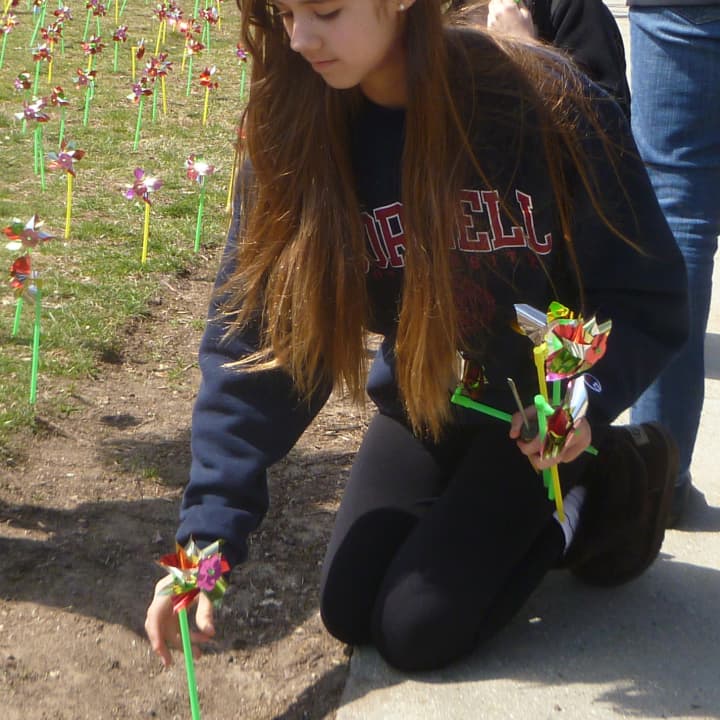Catalina Ruiz-Jimenez of Greenwich plants a pinwheel representing one of almost 2,000 children abused or neglected in Fairfield County last year.