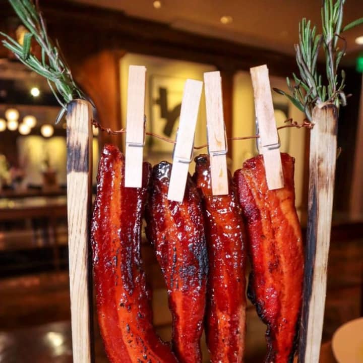 Candied bacon on a clothesline with maple, black pepper and a pickle from Red Salt Room, located in the Garden City Hotel on Long Island (45 7th Street in Garden City)