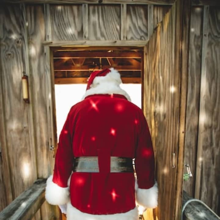 Stock image of a man dressed as Santa Clause walking away.