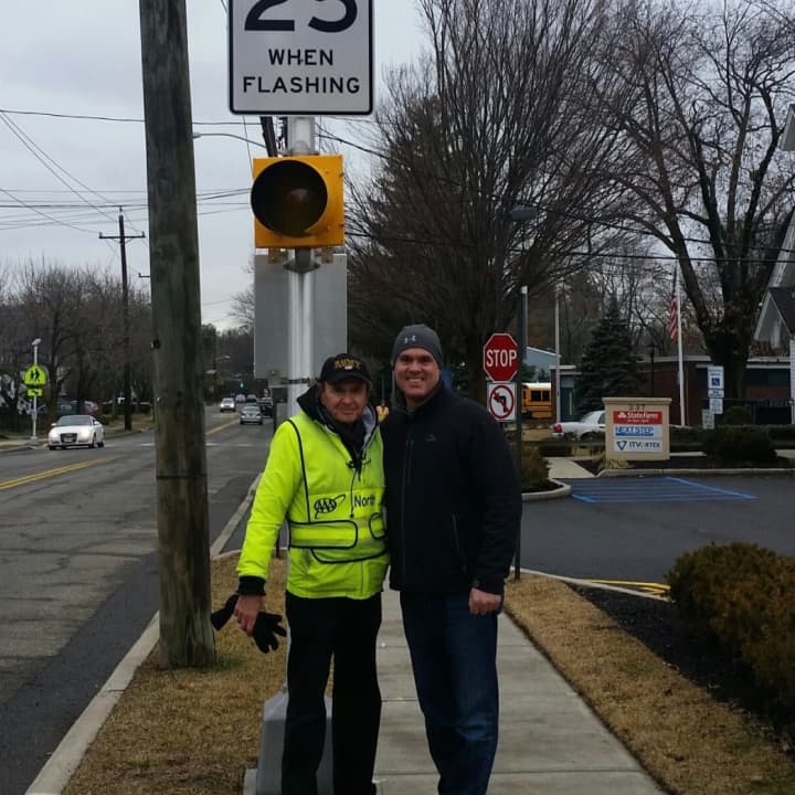 Paramus Mayor Rich LaBarbiera and a crossing guard pose with the new solar-powered LED system installed at several crosswalks in the borough.
