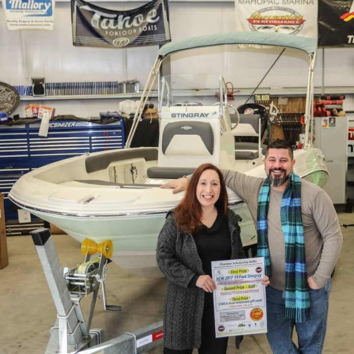 Faith Ann Butcher, Chairwoman of The Greater Mahopac-Carmel Chamber of Commerce, with Charles Melchner Jr. of Mahopac Marine in front of the 2017 19-foot Stingray that will be the grand prize in the Chamber Scholarship Raffle.