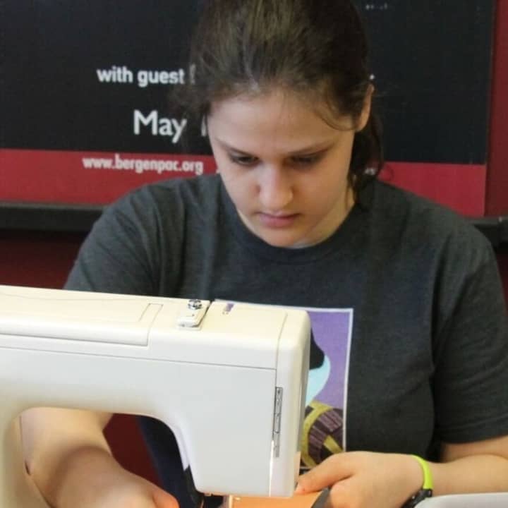 Ilana Lupkin, a member of the tech and production crew for summer musicals at The Performing Arts School at bergenPAC, working on a costume.