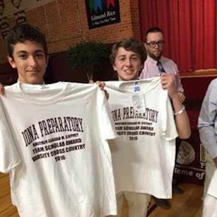 Junior Nick Mingione and sophomore Finn Barron, members of the Iona Prep Varsity Cross-Country Team, pose with their new team scholar award shirts.