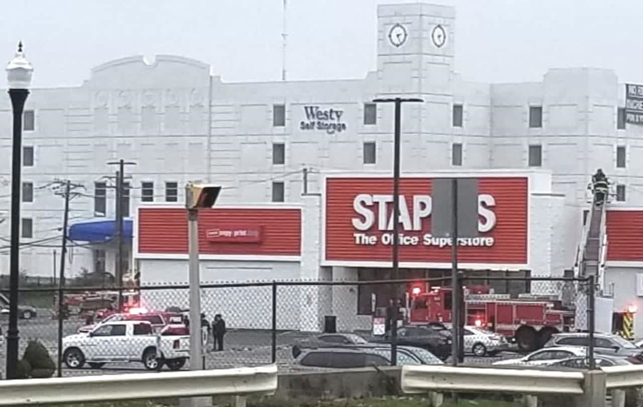 Hackensack firefighters tending to the smoky HVAC unit on top of the Staples store.