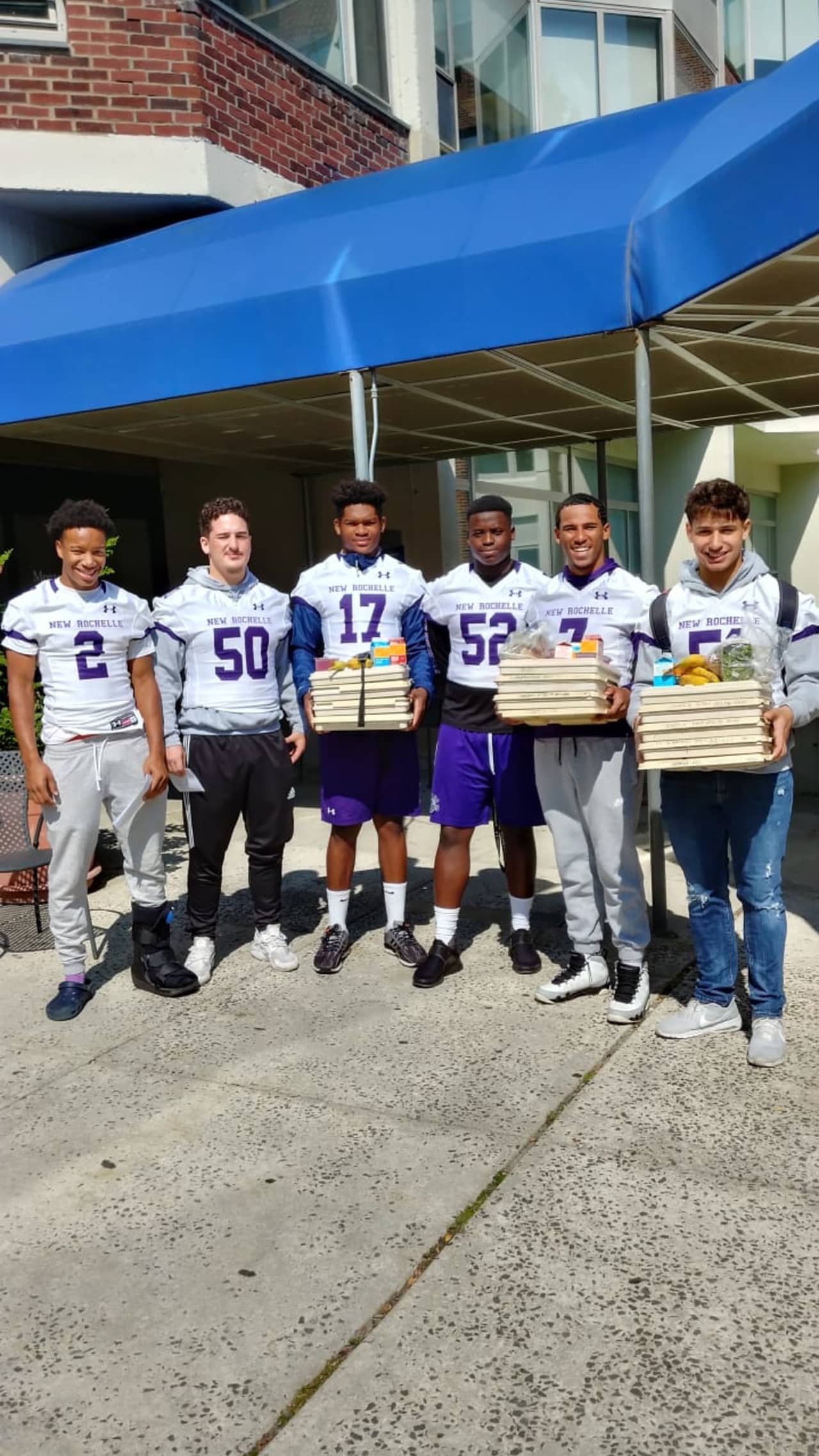 Players from the New Rochelle Varsity football team delivering meals to patients at Montefiore Hospital.