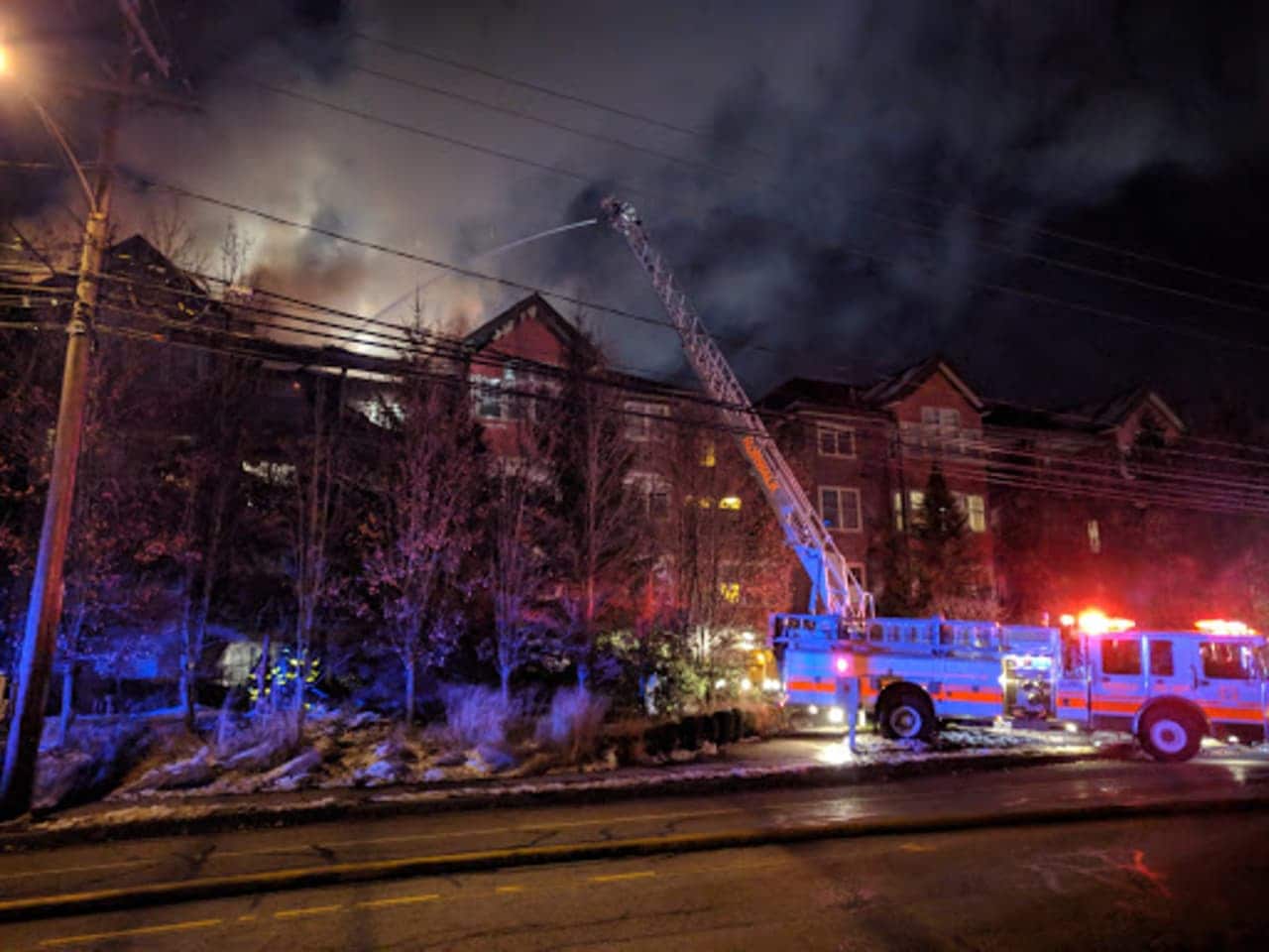 Fire crews attack the blaze from above in the condo building on Richards Avenue in Norwalk on Monday evening.