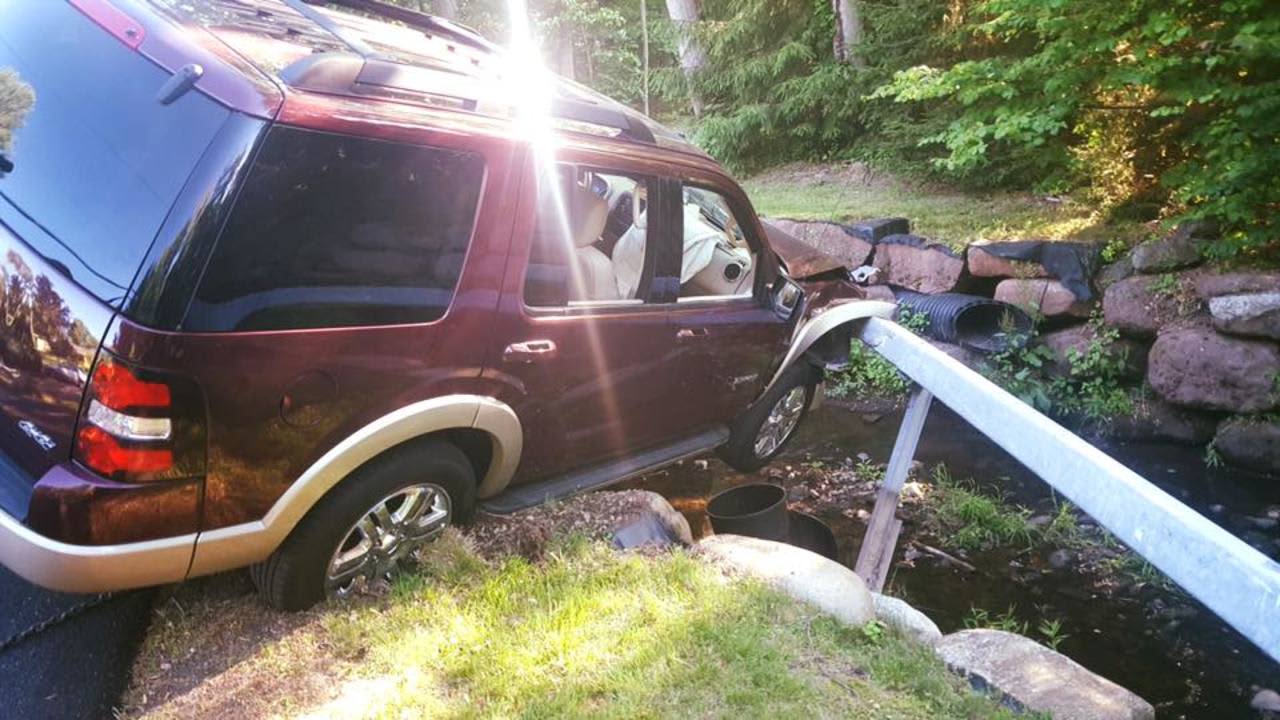 A vehicle sits precariously above the river.