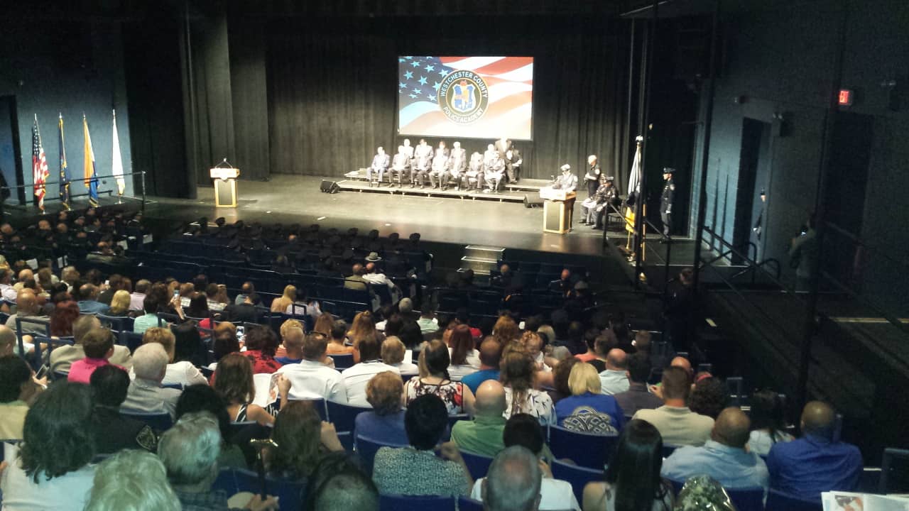 The deadline to apply for the Westchester County police officer exam is July 25. Hundreds of family members and fellow officers are shown at SUNY Purchase attending a graduation ceremony for the Westchester County Police Academy.