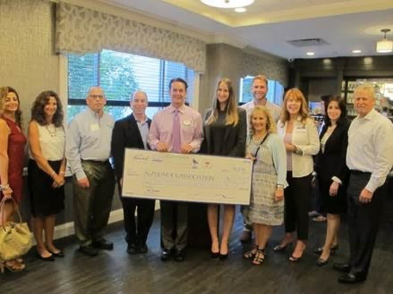 The Armonk, Mount Kisco, Somers, Greenwich and Chappaqua-Millwood Chambers of Commerce present a check for $2.985 to help fight Alzheimer's disease at the Bristal in Armonk