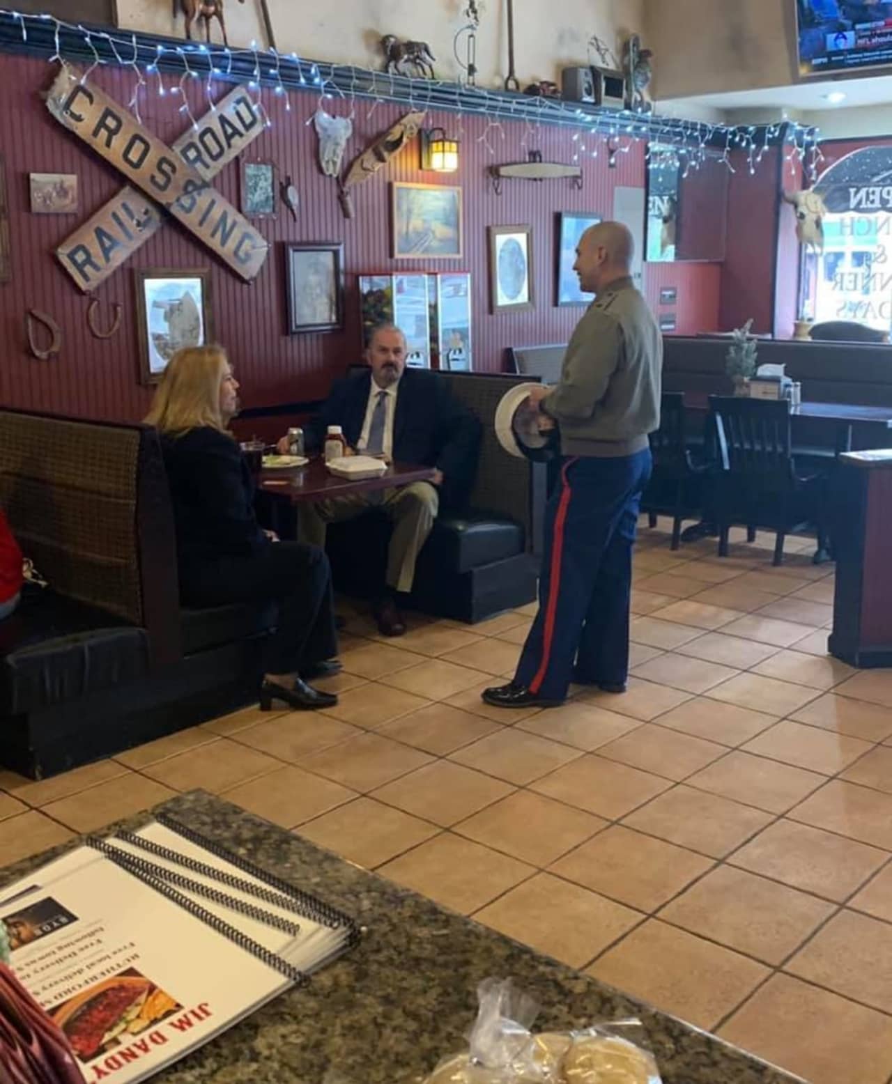 A U.S. Marine who recently relocated to the area had his lunch paid for by Rutherford councilwoman Stephanie McGowan, pictured here talking to him with her colleague from Felician University.