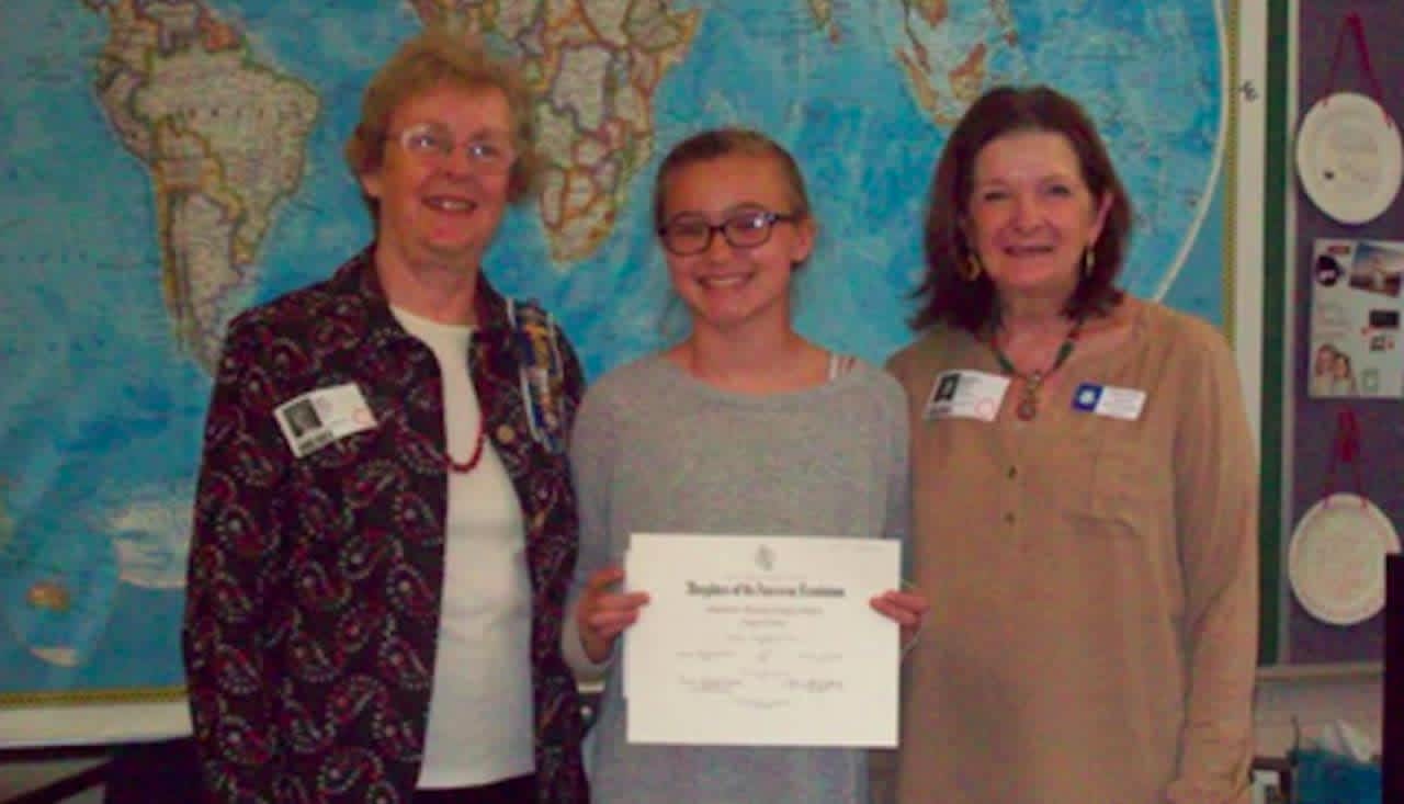 Molly Wunderlich (center) receives a first-place certificate and $25 check from the Daughters of the American Revolution. Left, Dianne Wells, DAR Chapter Regent and far right, Marge Pavlov, DAR Chapter Chairman, DAR Essay Contest.