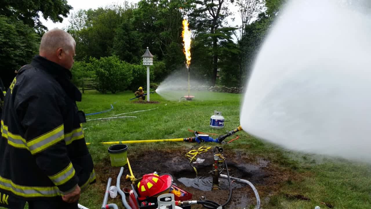 New Canaan Fire Department members work to burn off a leaking underground propane tank.