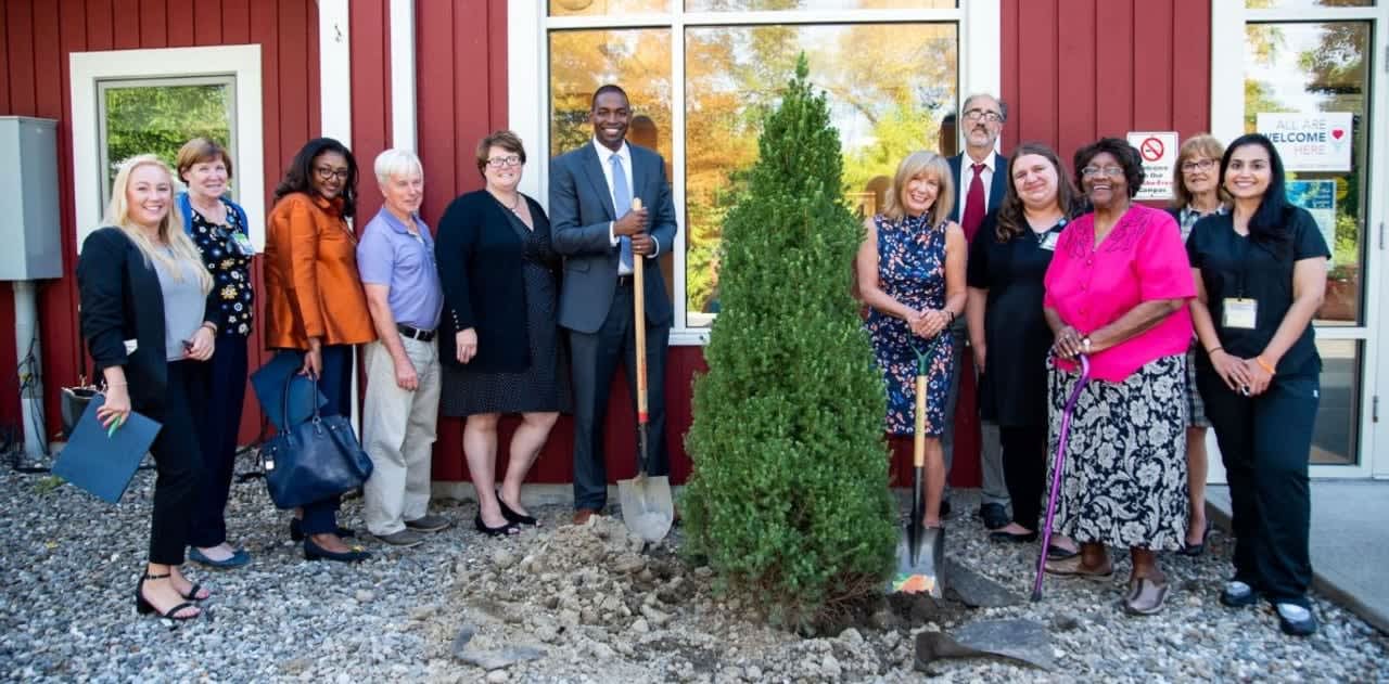 Congressman Antonio Delgado planting a tree outside the HRHCare Amenia Health Center with CEO Anne Kauffman Nolon, Founding Mother Rev. Jeannette J. Phillips, and other executives and staff.