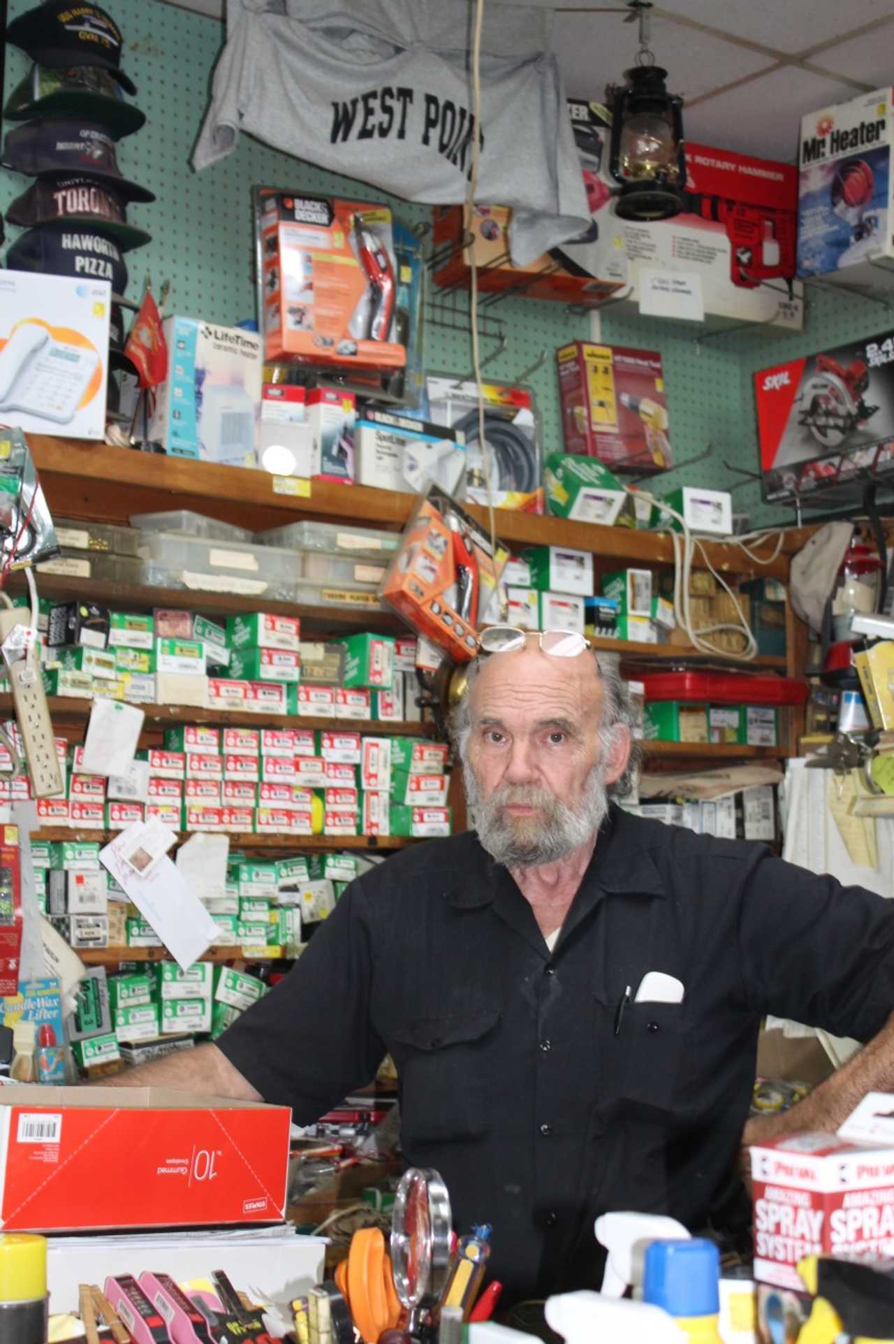Robert Sconfienza in his shop with a military display behind him. 