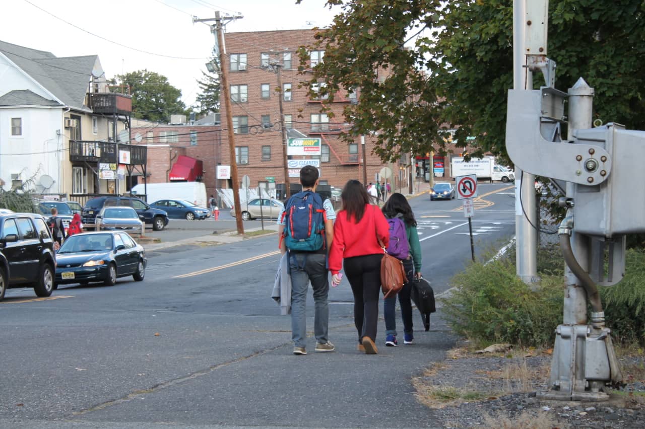 Students exit and walk along a busy roadway near Bergenfield High School.