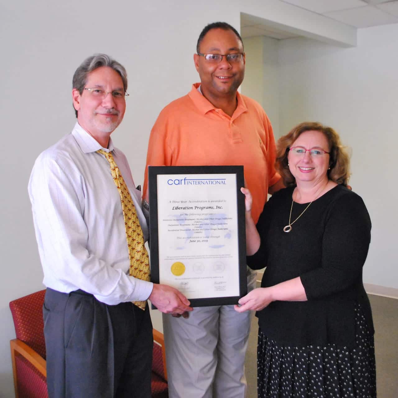 Liberation Programs' Cary Ostrow, chief administrative officer; Alan Mathis, president and CEO; and Dr. Patti Juliana, chief program officer, display three-year certification from CARF International.