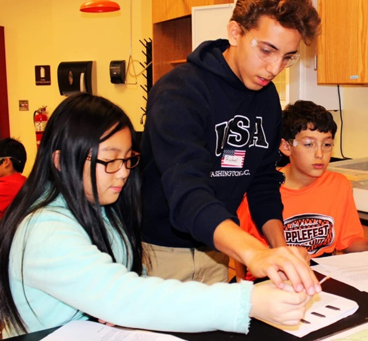 An Ossining High School student works with younger students to spur interest in science. Eight students from Ossining High School are semifinalists in the 2016 Intel Science Talent Search competition.