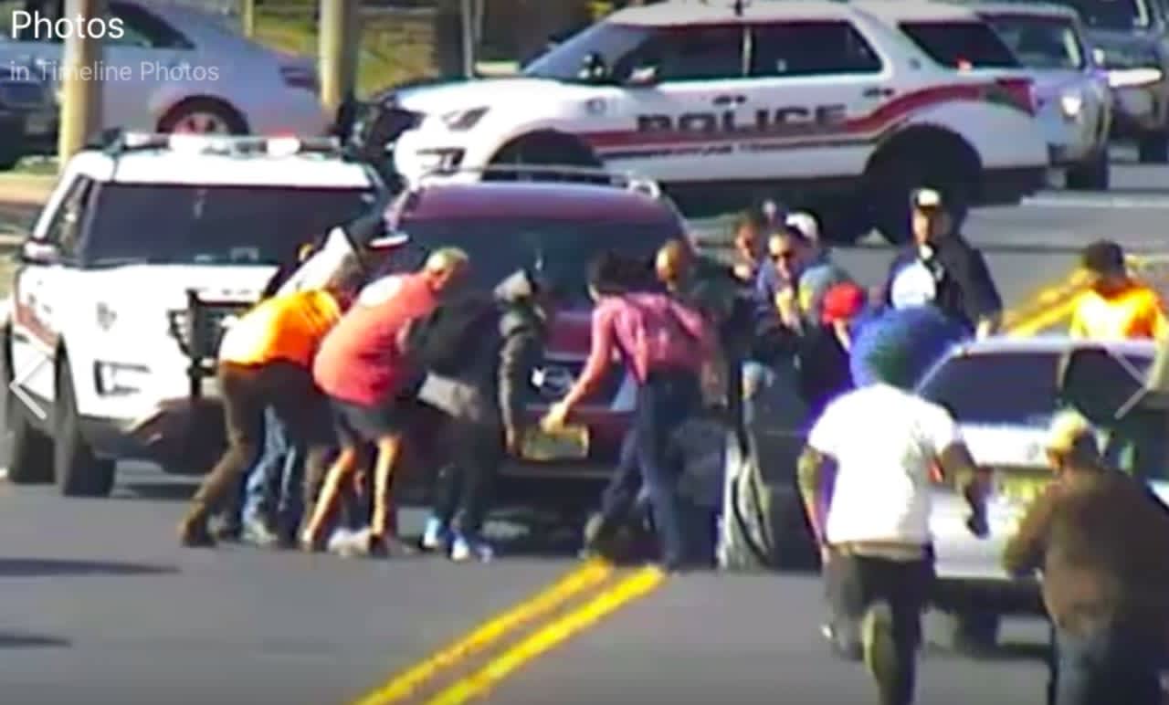 More than a dozen bystanders ran to help Neptune Township police rescue a bicyclist trapped under an SUV.