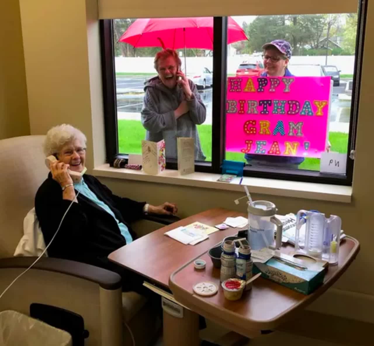 Jean Powell (seated, on phone) speaks with daughter Kim Wedemeyer (top left) and granddaugther Shaylin Bell (top right) on her 91st birthday, after beating COVID-19 (Photo: Encompass Health Rehabilitation Hospital of Toms River)