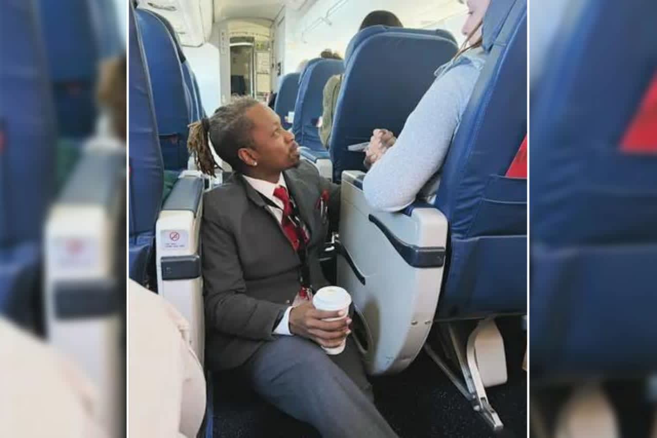 Delta flight attendant Floyd Dean-Shannon comforts a very nervous flier on a recent flight from Charlotte, North Carolina to JFK.