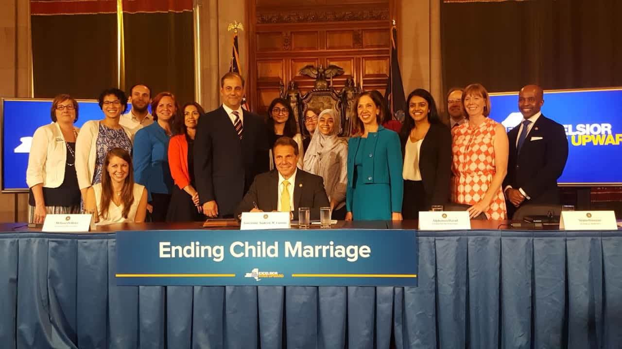 Gov. Cuomo is flanked by supporters as he signs a bill ending child marriage in New York.