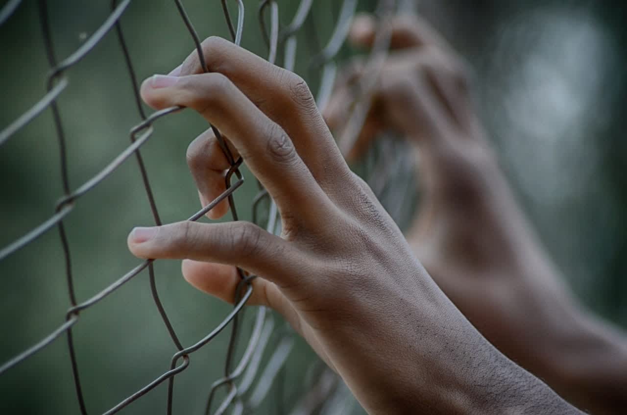 Hands on fence