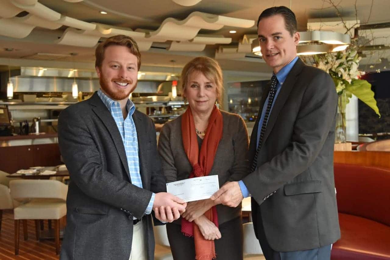 Anthony DiLauro , right, and Ellen Appleby, center, receive a donation from Adam Zakka of Mediterraneo.