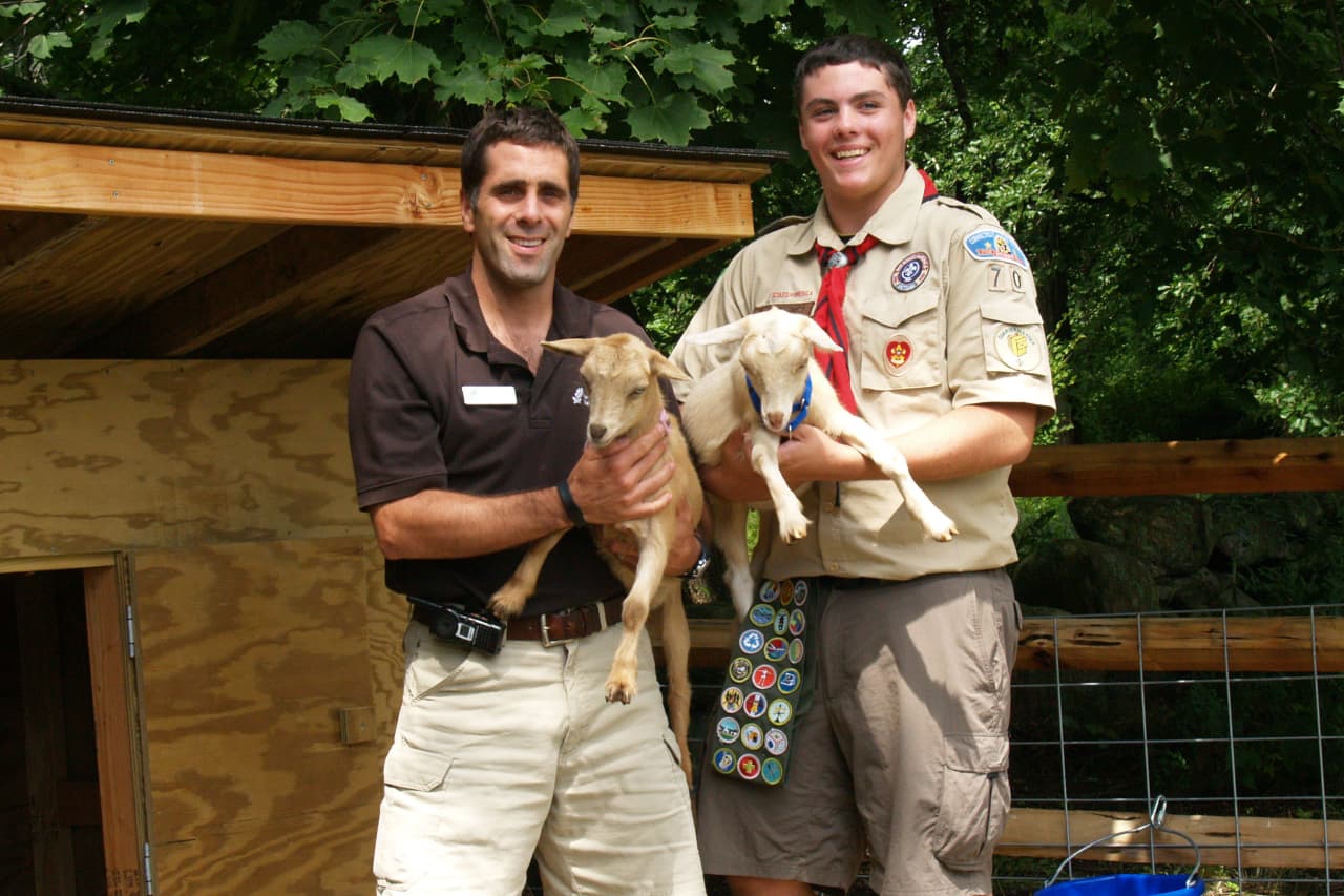 New Canaan Nature Center Director of Education Keith Marshall and Eagle Scout Jake Melcher show off the center's new baby goats.