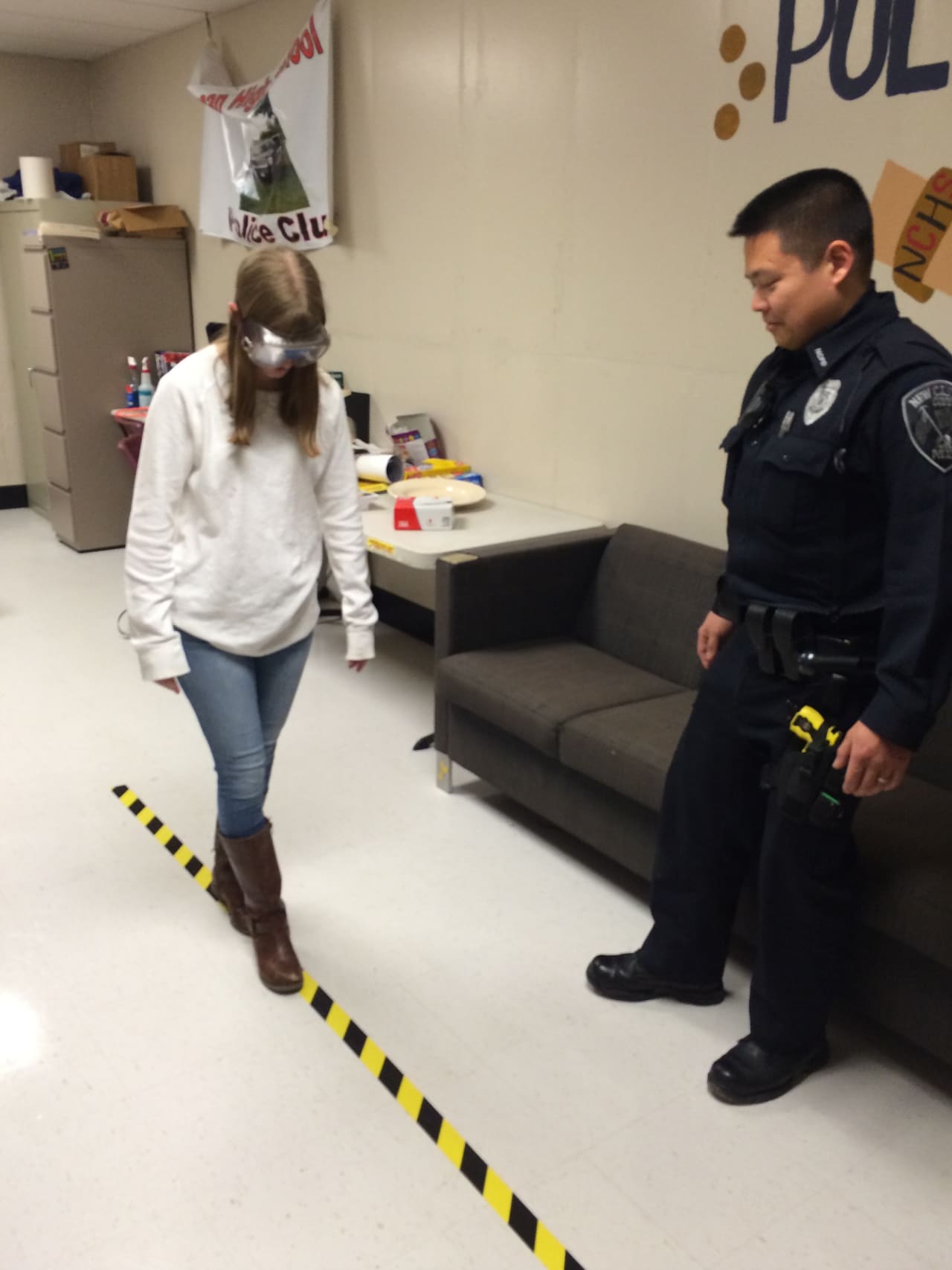 Eliza Haney navigates a straight line while wearing Fatal Vision Goggles that simulate the impact of alcohol on coordination.