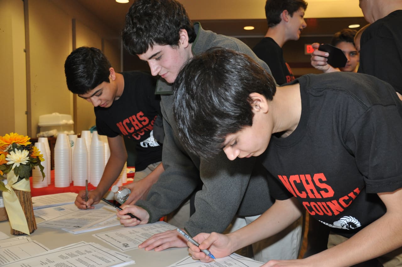 New Canaan High students sign a pledge to not text and drive. 