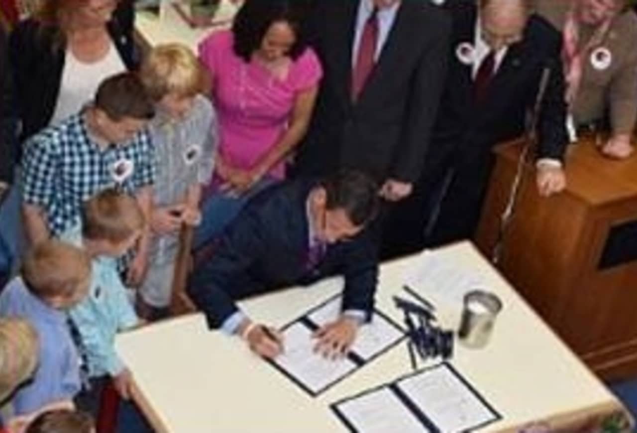 Gov. Dannel P. Malloy signs Public Acts No. 14-39 and 14-41 at Helen Street School in Hamden on Wednesday, May 28.