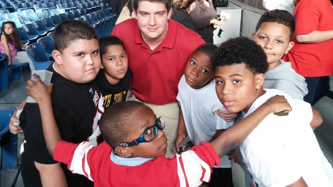 Somers High School's James Lucadamo huddles with the Yonkers players he is sending to football camp this summer after he raised scholarship money in a Mud Run.