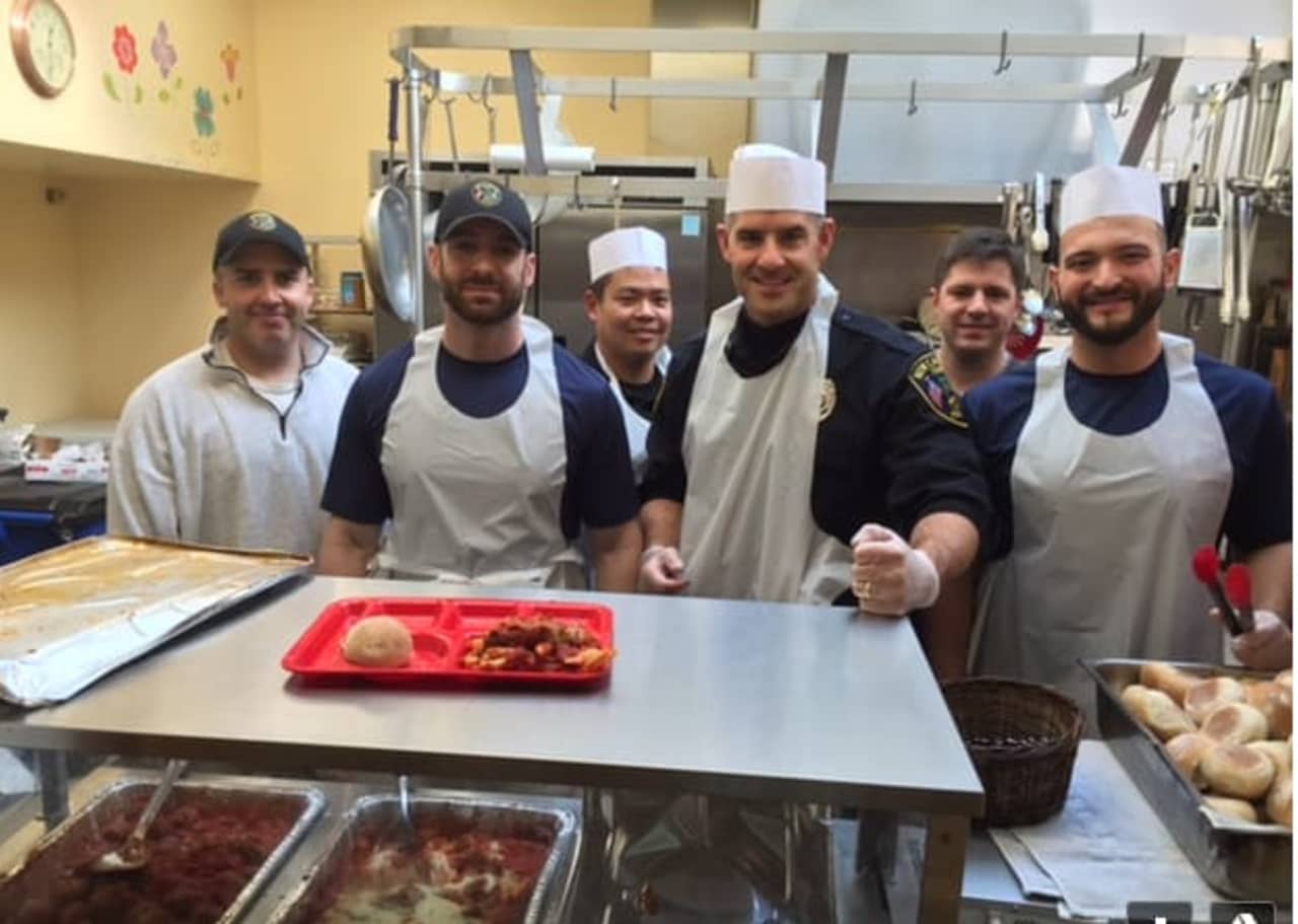 New Canaan police offices help prepare and serve lunch at Norwalks Open Door Homeless Shelter. 