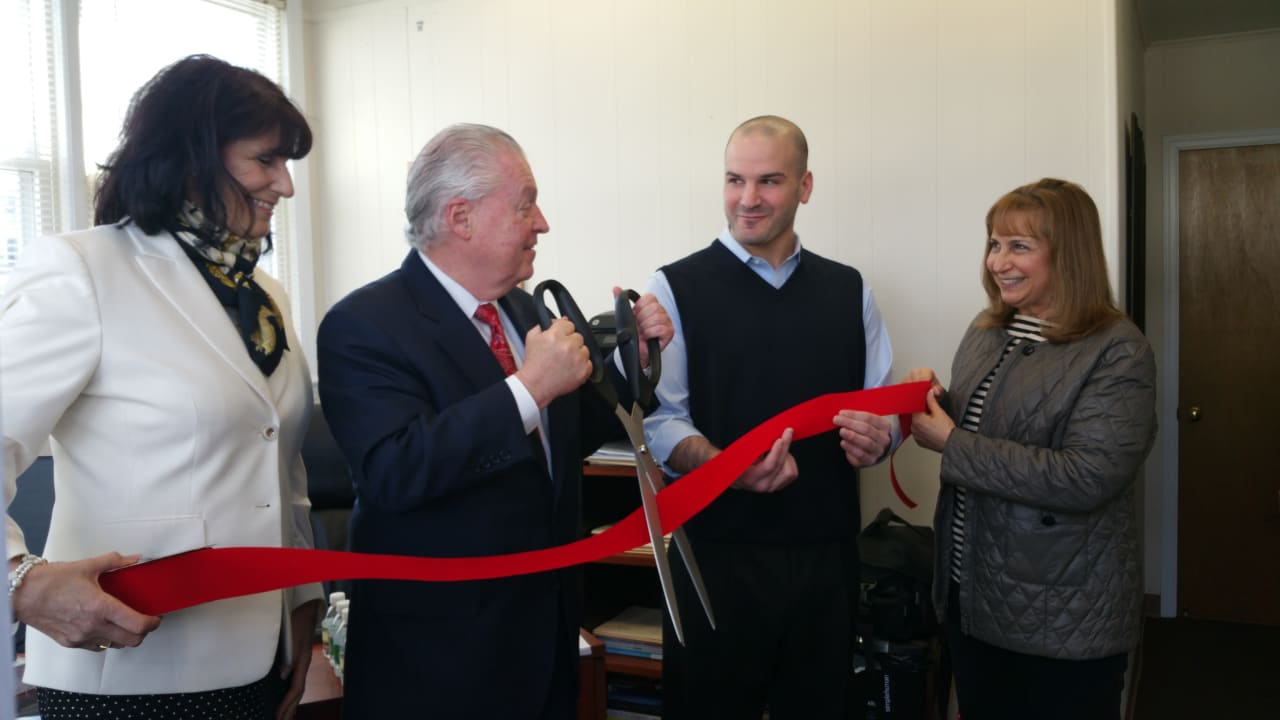 (right-center) Scott Lipow, CEO of Six7Marketing, watches First Selectman Mike Tetreau cut the ribbon on his business's new office front at 1901 Post Road.