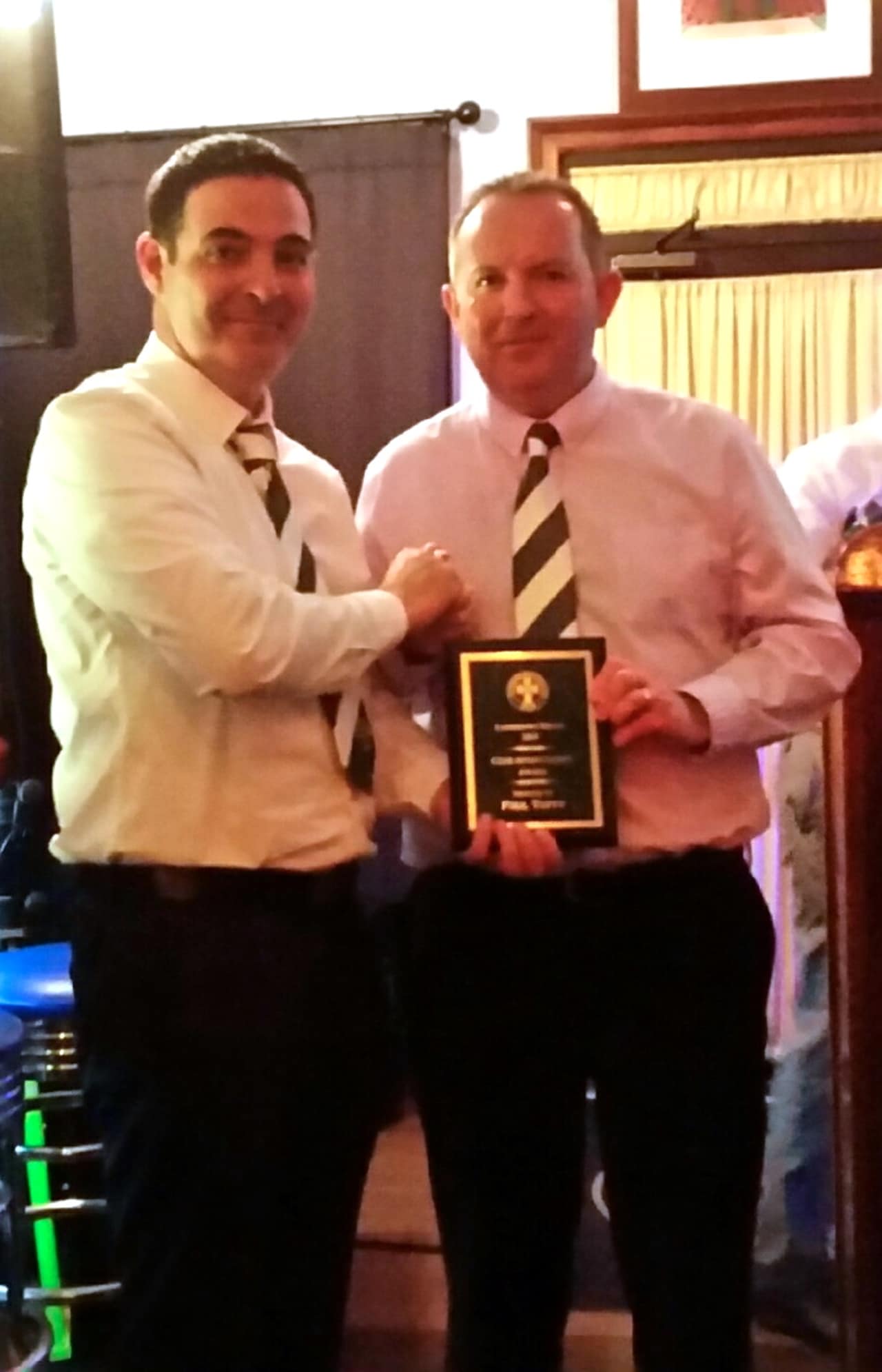 Yonkers businessman Paul Tuffy, right, accepts an award recently from William McGrory, president of the Lansdowne Bhoys Football Club.