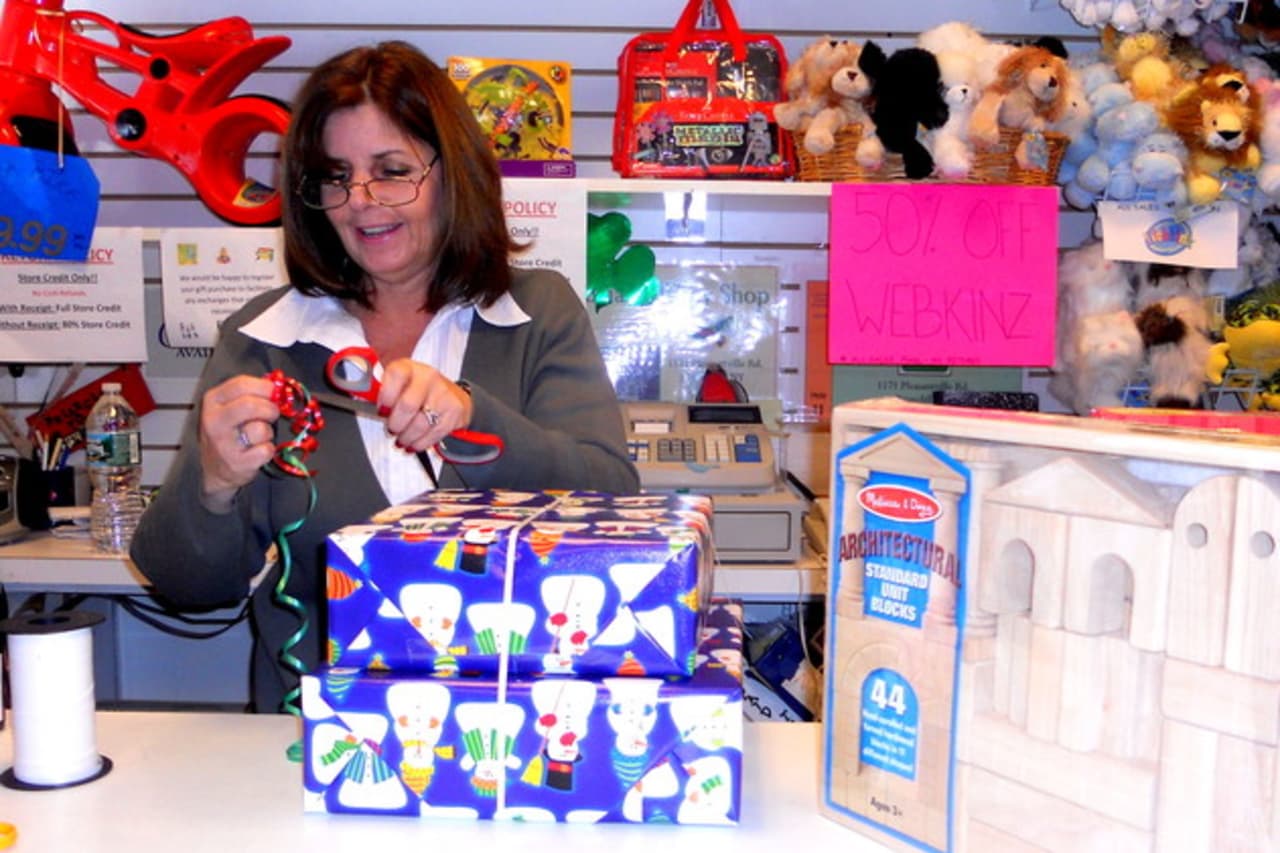Denise Edwards of Briarcliff Toy Shop wrapping a holiday present last year. On Saturday, small retailers are offering discounts for Small Business Saturday.