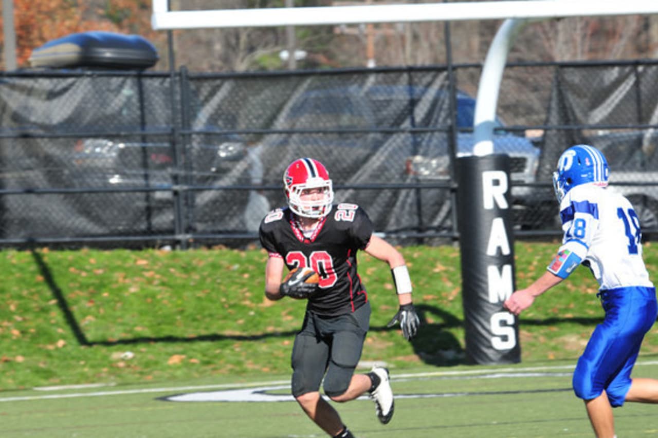 New Canaan freshman Kyle Smith looks to elude a Darien defender during a game last week. New Canaan finished the season 8-0.