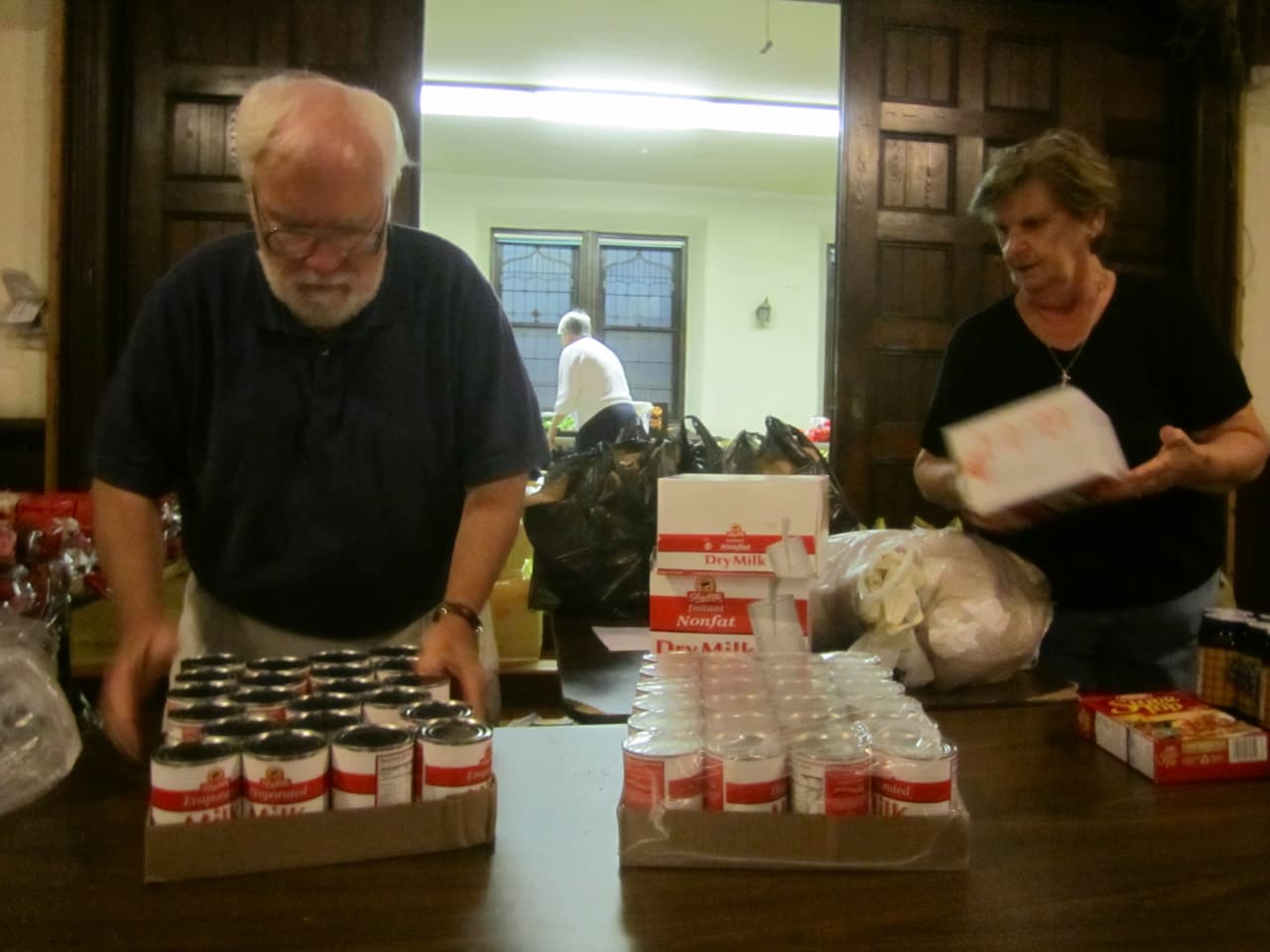 Volunteers Richard Devir Margaret Young prepare food items in September for the Ossining Food Pantry. The pantry is one of several in Ossining and Briarcliff Manor receiving goods through fundraisers this holiday season.