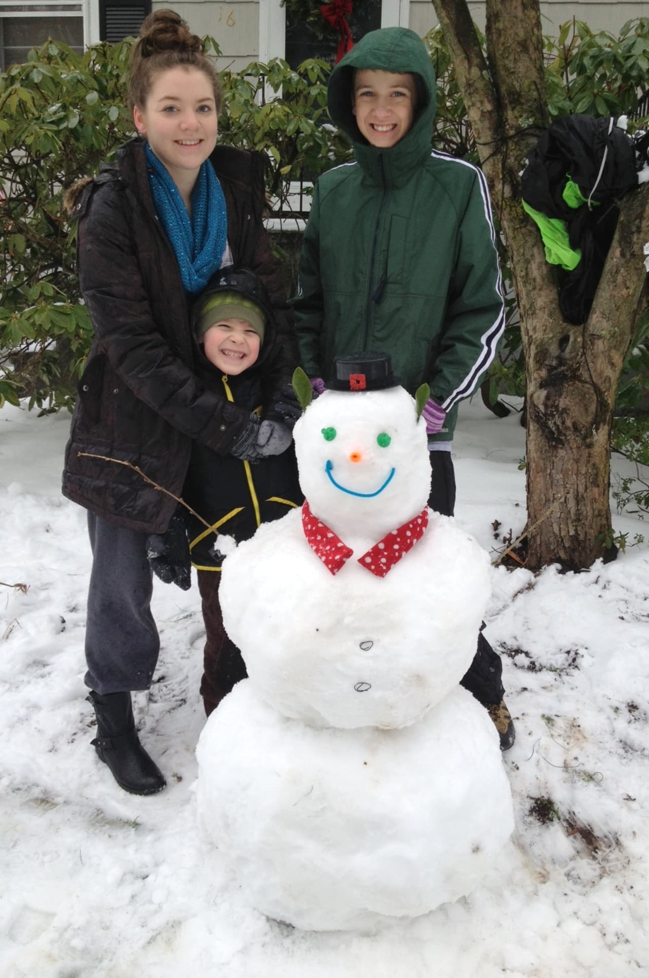 Taylor Copeland-York, left,  17, Luke Camarlinghi, 13, and Ethan Goormastic, 6, of New Canaan made a snowman Wednesday on their snowy day off from school. 