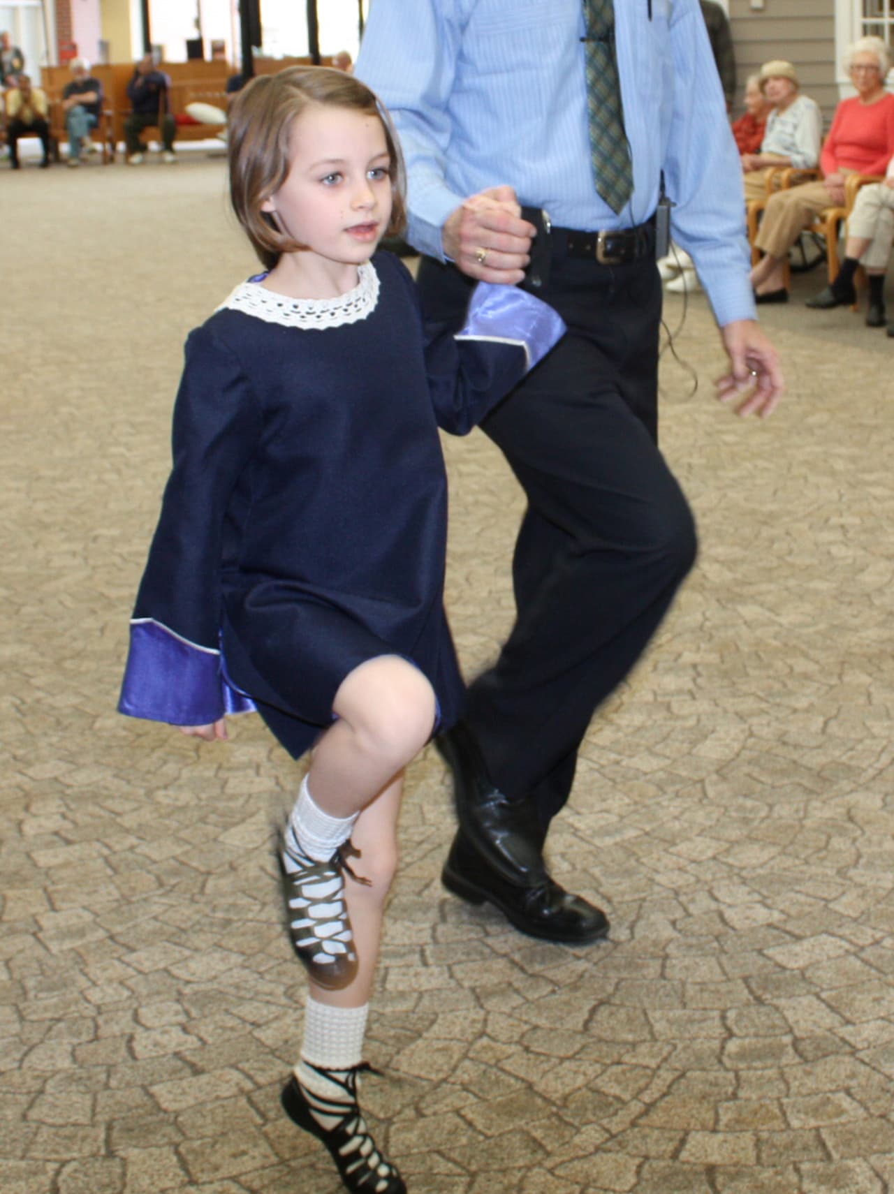 Sasha Coughlin does the Irish Jig for her grandmother, Barbara Coughlin, and the rest of the community at the Village of Waveny Care Center. 