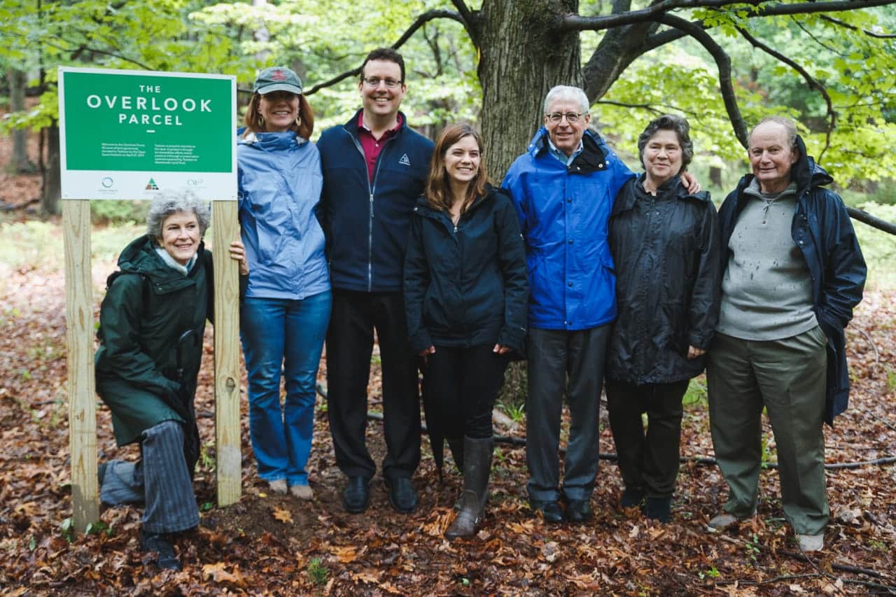 Merrilee Ingui, Lori Ensinger, and Kevin Carter are joined by Teatown Board Members next to a new sign, which will stay on the property to commemorate the gift.