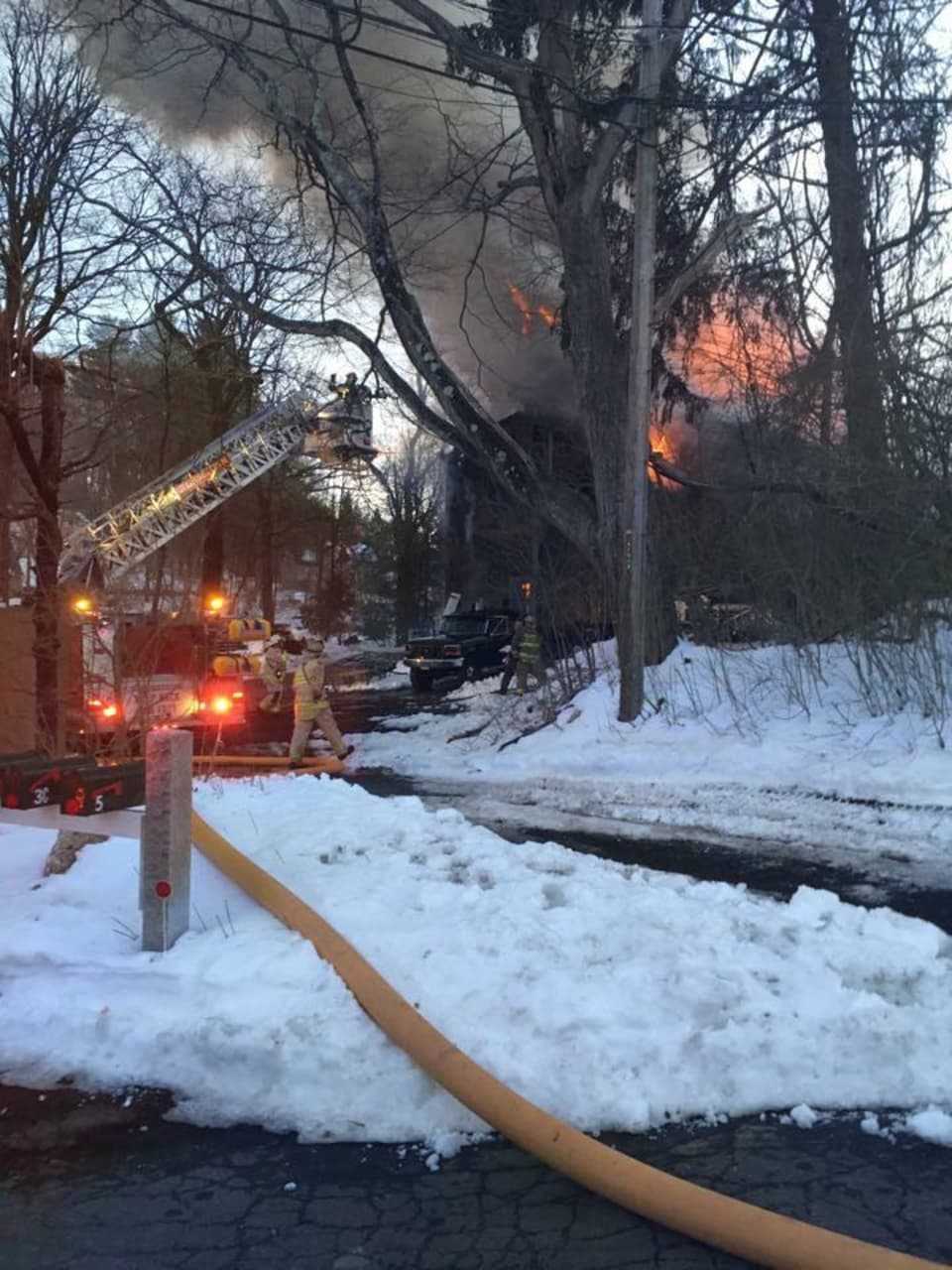 A hose is stretched at the scene of the barn fire on Church Street.