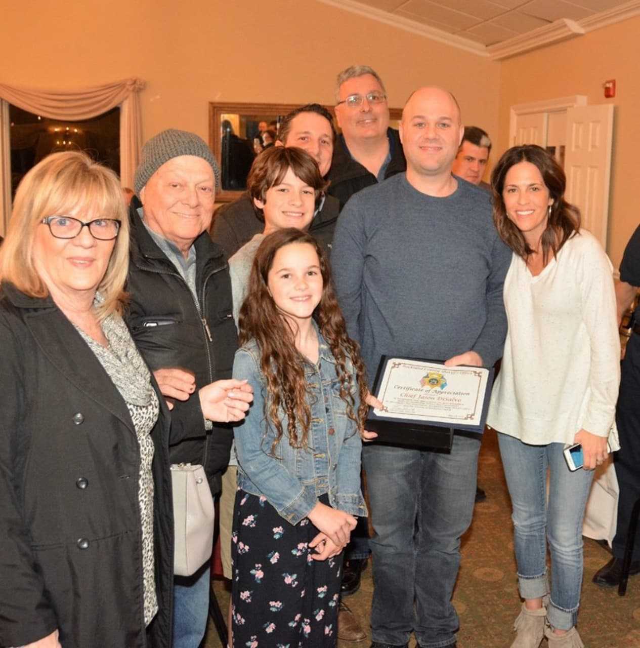 Jason DiSalvo, surrounded by family, shows off his award.
