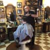 Mark Sinnis gives one of his few remaining hair cuts at his Beale Street Barber Shop in Peekskill Wednesday. He is packing up and moving his four-year-old business to North Carolina.