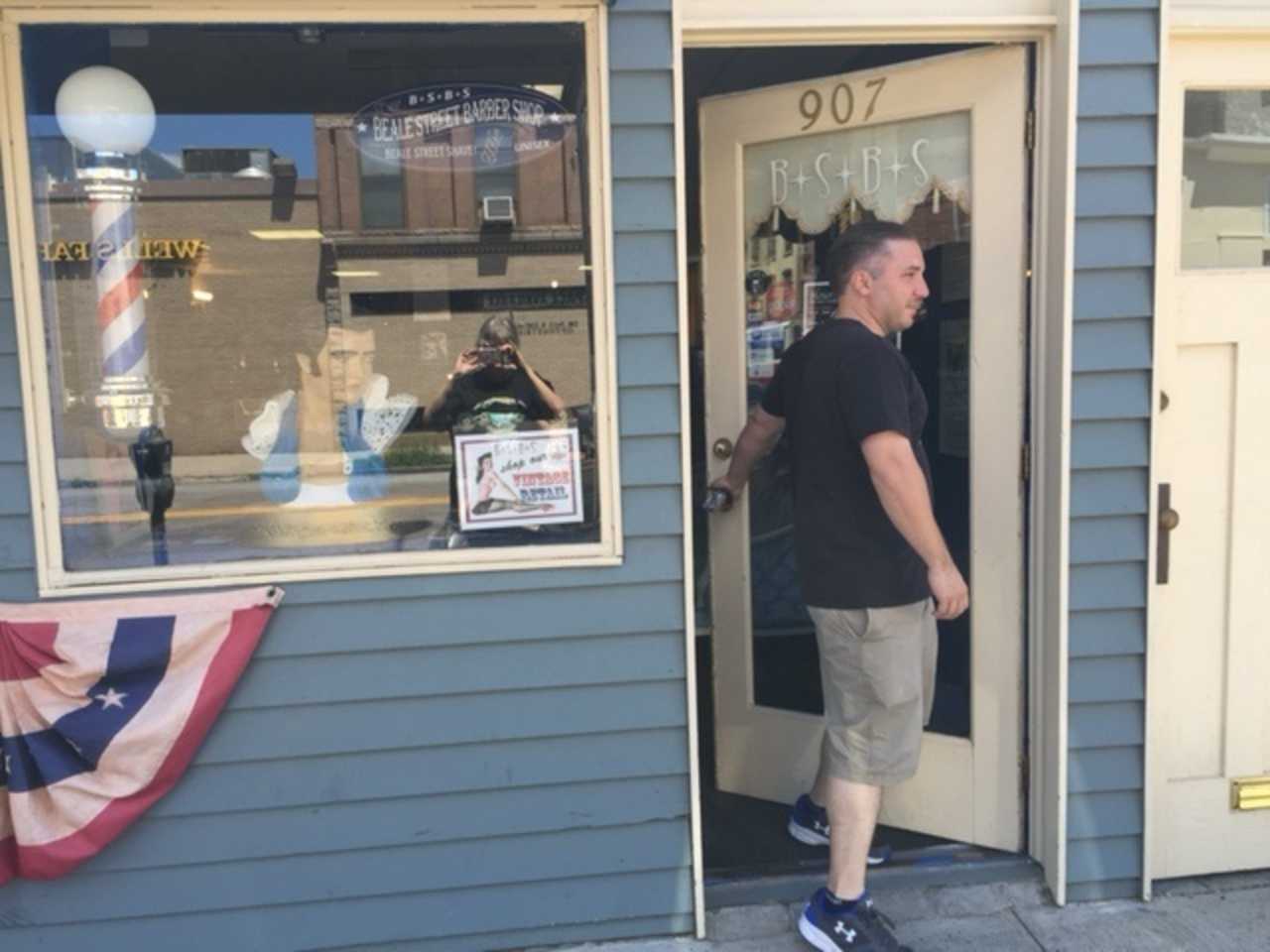 Newly shorn, one of Mark Sinnis' last customers leaves the Beale Street Barber Shop in Peekskill Wednesday.